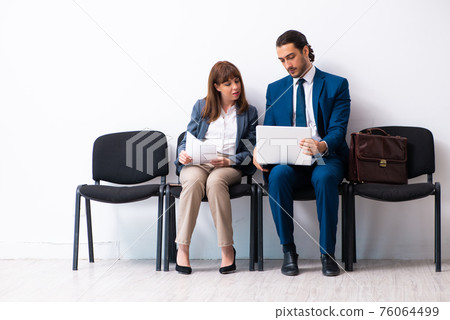 Young businessman and businesswoman waiting for an interview at 76064499