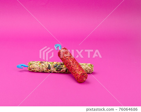 Food for rodents on a pink background. Diet in chopsticks for pets. Food for rodents on a pink background. Diet in chopsticks for pets. 76064686