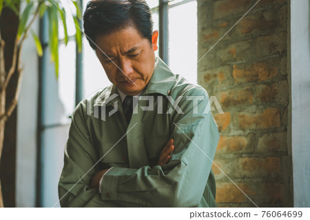 A man in work clothes and a tie A man in work clothes and a tie 76064699