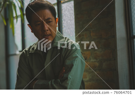 A man in work clothes and a tie A man in work clothes and a tie 76064701