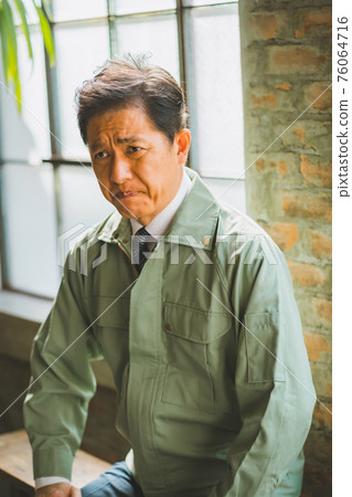 一個穿著工作服打著領帶的男人 76064716