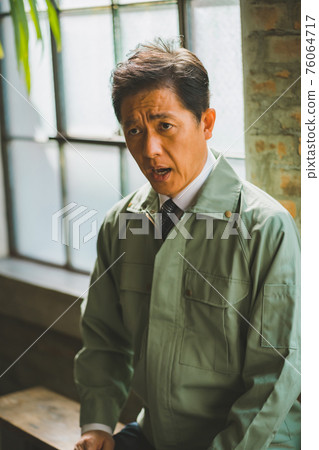 一個穿著工作服打著領帶的男人 76064717