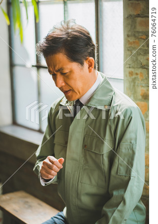 A man in work clothes and a tie A man in work clothes and a tie 76064719