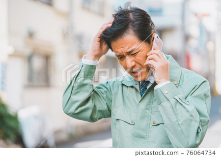 一個穿著工作服打著領帶的男人在電話裡生氣 一個穿著工作服打著領帶的男人在電話裡生氣 76064734