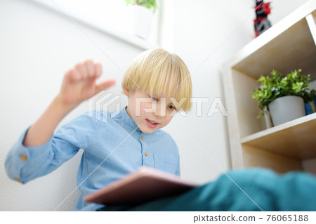 Preschooler boy playing pc game by tablet. Overuse and addiction kids from gadgets. Preschooler boy playing pc game by tablet. Overuse and addiction kids from gadgets. 76065188