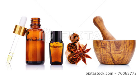 Cinnamon essential oil bottle with Ceylon cinnamon sticks and anise star isolated on white background .. 76065772