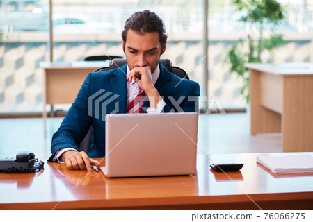 Young handsome employee working in the office Young handsome employee working in the office 76066275