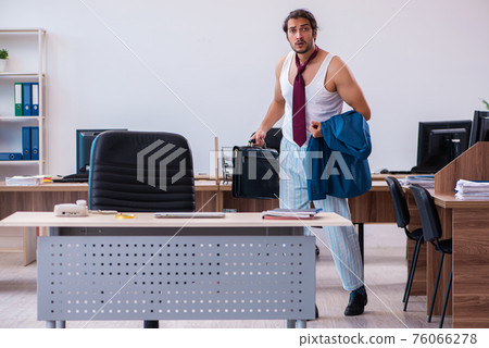 Young male employee coming to work straight from bed Young male employee coming to work straight from bed 76066278