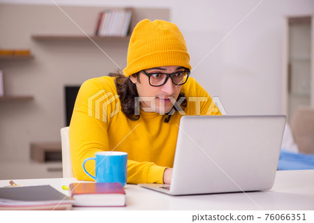 Young male student preparing for exams at home 76066351