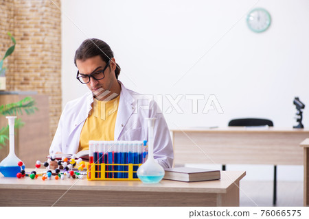 Young male chemist student in the classroom 76066575