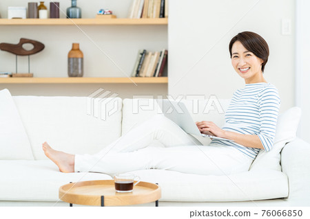 在沙發上玩筆記本電腦的女人 在沙發上玩筆記本電腦的女人 76066850