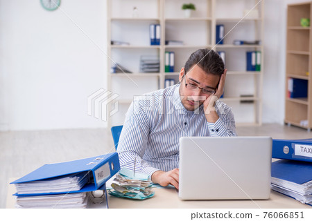 Young male bookkeeper calculating tax payments in the office Young male bookkeeper calculating tax payments in the office 76066851