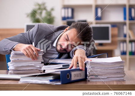 Young businessman employee unhappy with excessive work in the of 76067146