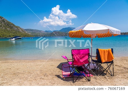 Umbrella and sundecks on beach, Greece 76067169