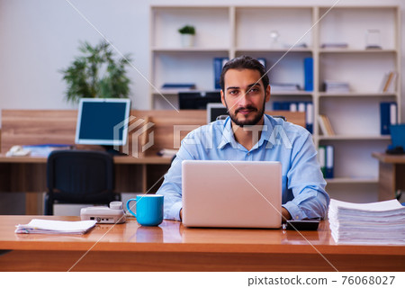 Young male employee working in the office Young male employee working in the office 76068027