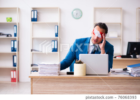 Blindfolded male employee working in the office 76068393