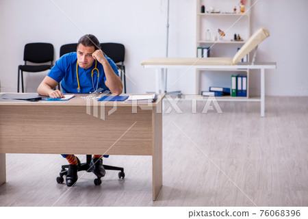 Young male doctor being unhappy after night shift Young male doctor being unhappy after night shift 76068396