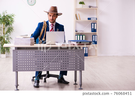 Young businessman cowboy working in the office 76068451