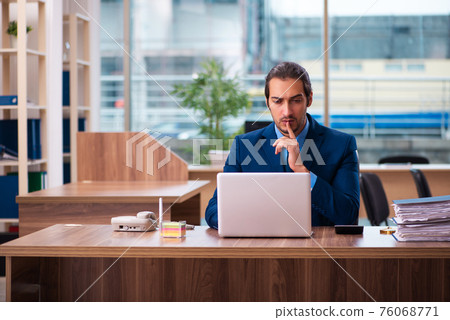 Young male employee working in the office Young male employee working in the office 76068771