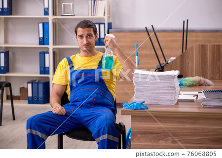 Young male contractor cleaning the office 76068805