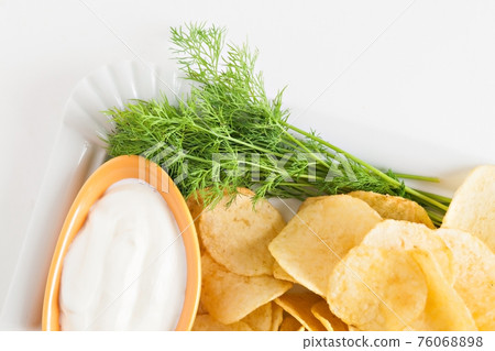 chips with sour cream and dill sauce isolated 76068898