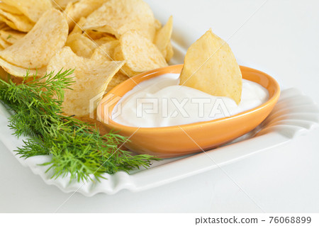 chips with sour cream and dill sauce isolated 76068899