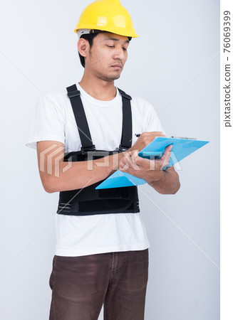 Worker Man stand write book note wearing back support Worker Man stand write book note wearing back support 76069399