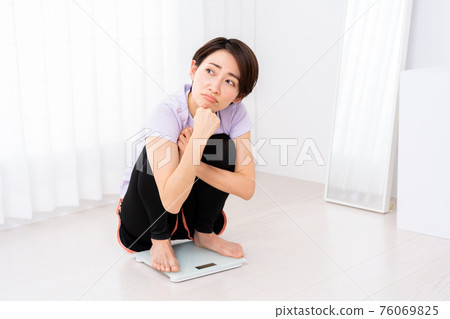 Middle-aged woman shocked by scale after training 76069825