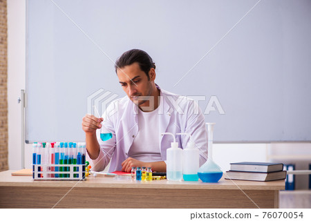 Young male chemistry teacher in the classroom Young male chemistry teacher in the classroom 76070054