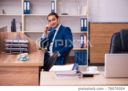 Young male employee working in the office Young male employee working in the office 76070084
