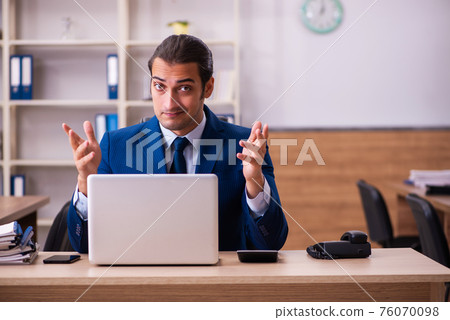 Young male employee working in the office Young male employee working in the office 76070098