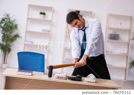 Young male call center operator working at his desk 76070112