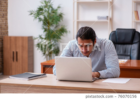 Young male employee sitting in the office 76070156