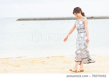 Woman walking on the beach Woman walking on the beach 76070492
