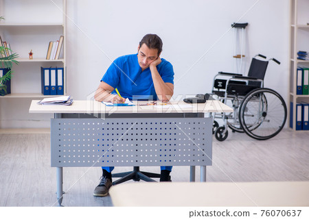 Young male doctor writing prescription in the clinic Young male doctor writing prescription in the clinic 76070637