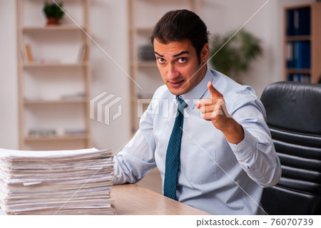 Young male employee unhappy with excessive work 76070739