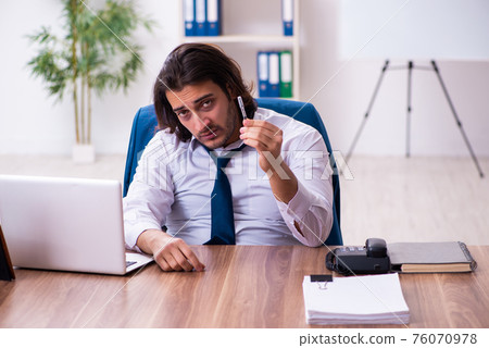 Drug addicted male employee working in the office 76070978