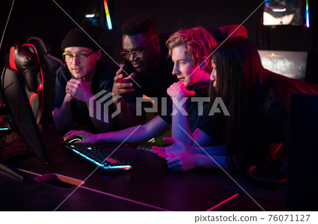 Players of the esports team gathered together in the computer club and watch the stream from the dota 2 world championship 76071127