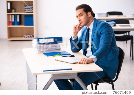 Young businessman employee sitting in the office Young businessman employee sitting in the office 76071409