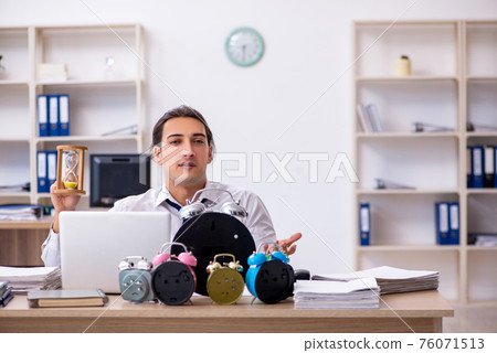 Young male employee afraid of missing deadline at workplace Young male employee afraid of missing deadline at workplace 76071513