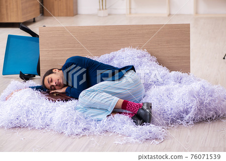 Young male employee and a lot of cut papers in the office 76071539