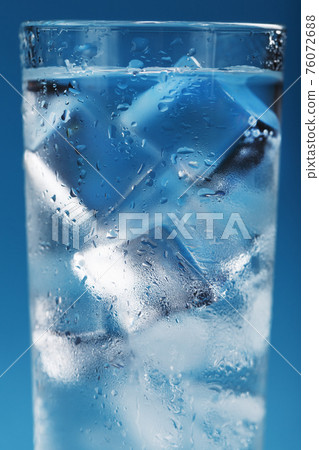 Ice cubes in a misted glass with drops of ice water close-up macro. 76072688