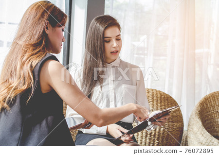 Young Asian. women Business people meeting point to discuss, plan. Young Asian. women Business people meeting point to discuss, plan. 76072895