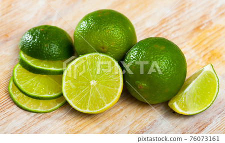 Ripe lime and knife on wooden cutting board Ripe lime and knife on wooden cutting board 76073161