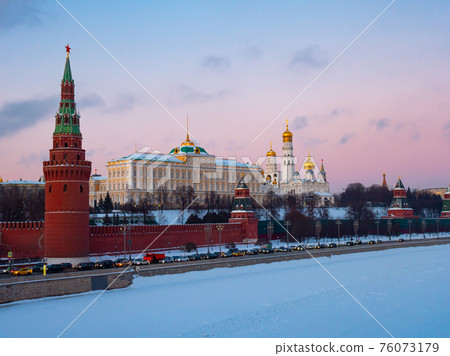 Moscow Kremlin on bank of snow covered Moskva River at sunset 76073179