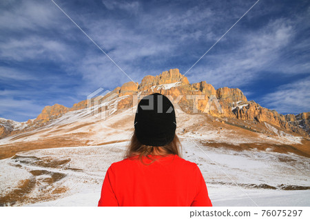 man in a hat stands with his back against the background of mountains days man in a hat stands with his back against the background of mountains days 76075297
