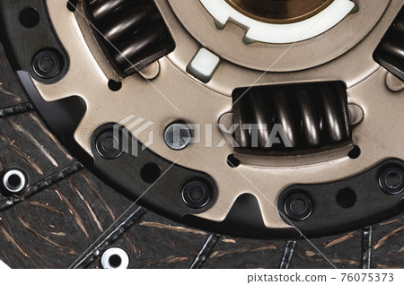 Clutch disc of a manual transmission of a passenger car on a gray background. Close-up detail view 76075373