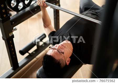 亞洲男子在訓練館做臥推 亞洲男子在訓練館做臥推 76075562