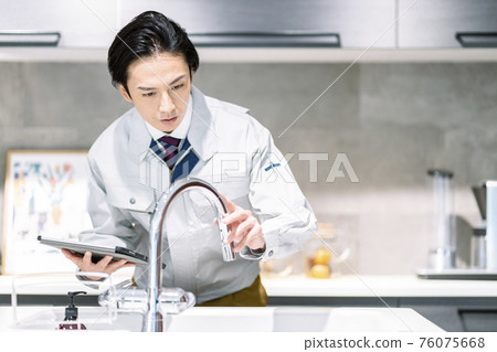 Workers checking the water services in the kitchen 76075668