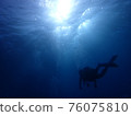 Silhouette of a diver swimming in the sea 2 76075810